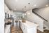 Contemporary open-concept kitchen with sleek white cabinets and pendant lighting.