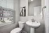 Bright bathroom interior with modern fixtures, artistic wall decor, and a view of the neighborhood.