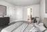 Inviting bedroom with a cozy bed, soft carpeting, stylish decor, and a glimpse into an ensuite bathroom.