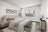 Bright and stylish bedroom with modern decor, featuring a plush bed, large windows, and minimalist furnishings.