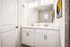 Modern bathroom with double vanity, sleek faucets, and artistic wall decor.