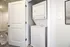 Efficient in-unit laundry setup featuring a stacked washer and dryer in a convenient closet space.