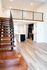 Stylish open-concept loft with a modern kitchen and wooden staircase leading to an upper level.