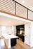 Bright open kitchen featuring modern black cabinetry and a sleek island with wooden flooring.