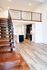 Elegant loft apartment showcasing an open kitchen, wooden staircase, and bright living space.
