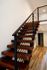 Sleek wooden staircase with modern black railings in a contemporary interior setting.