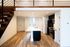 Elegant loft kitchen with modern appliances, spacious island, and warm wooden flooring.