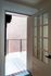 Inviting doorway opening to a private balcony with a view of a rustic brick wall.