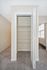 Open closet with shelving featuring plush carpet and ample natural light in modern apartment.