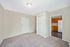 Bright and open entryway leading to a modern kitchen with wooden cabinetry and white appliances.