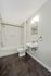 Modern bathroom featuring a pristine bathtub, elegant sink, and polished tile flooring.