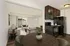Contemporary open-concept kitchen and living room with sleek black appliances, cozy seating area, and large windows offering plenty of natural light.