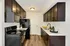 Modern kitchen with sleek dark cabinetry, stainless steel appliances, and chic decor accents.