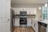 Modern kitchen design with sleek white cabinets, stainless steel appliances, and elegant lighting.