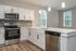Modern kitchen with sleek stainless steel appliances, elegant white cabinetry, and stylish pendant lighting, exuding contemporary charm and functionality.