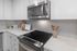 Modern kitchen with sleek stainless steel appliances, pristine white cabinetry, and elegant countertops.