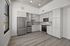 Sleek modern kitchen with stainless steel appliances, elegant cabinetry, and natural light streaming through a large window.
