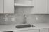 Modern kitchen with sleek gray subway tile backsplash, elegant white cabinetry, and a stylish stainless steel faucet.