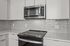 Modern kitchen with sleek stainless steel appliances, glossy subway tile backsplash, and pristine white cabinetry for a contemporary look.