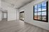 Bright and airy living space featuring modern wooden floors, large windows with a scenic view, and stylish ceiling fan.