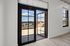 Bright apartment interior featuring large glass doors opening to a sunny terrace with stunning views.