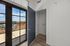 Charming apartment view with large French doors opening onto a sunlit balcony, showcasing stunning sky and cityscape.