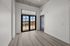 Bright and modern apartment room with large windows, sleek hardwood floors, and an inviting balcony view.