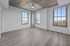 Bright and modern room featuring expansive windows and sleek wood flooring, complemented by an industrial-style ceiling fan.