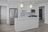 Bright modern kitchen featuring sleek stainless steel appliances, white cabinetry, and an elegant island with pendant lighting.