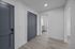 Modern apartment entryway featuring sleek gray doors, elegant laminate flooring, and a glimpse of the bright, spacious interior.