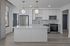 Modern kitchen with sleek white cabinetry, stainless steel appliances, and elegant pendant lighting.