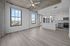 Modern apartment with open-concept design, featuring sleek kitchen with stainless steel appliances, large windows offering scenic views, and chic light fixtures.