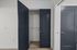 Chic apartment showcasing a sleek, modern closet with stylish navy double doors and pristine white interior walls.