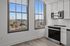 Bright kitchen with modern appliances and large windows offering stunning city and bridge views.