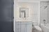 Modern bathroom featuring a sleek vanity with under-cabinet storage, an illuminated mirror, and a pristine bathtub-shower combination.