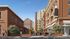 Charming urban apartment complex with classic brick architecture, lush greenery, and vibrant community life.