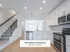 Bright and modern kitchen in The Select Collection at Annex West Townhomes featuring sleek cabinetry, stainless steel appliances, and elegant lighting.