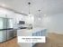 Modern kitchen in Annex West Townhomes with sleek stainless steel appliances, elegant pendant lighting, and spacious white cabinetry.