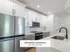Sleek modern kitchen in Annex West Townhomes with stainless steel appliances, elegant white cabinetry, and a spacious island sink. The Select Collection.