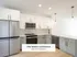 Modern kitchen in The Select Collection at Annex West Townhomes featuring sleek cabinetry, stainless steel appliances, and elegant pendant lighting.