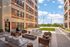 Charming apartment patio with cozy seating, string lights, and lush greenery, perfect for outdoor relaxation.
