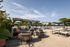 Spacious outdoor patio area with stylish seating, lush greenery, and pool view in a modern apartment community.