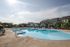 Luxurious outdoor pool area with modern cabanas, stylish seating, and sunlit ambiance perfect for relaxation.