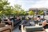 Chic outdoor patio setup with stylish lounge furniture, vibrant cushions, and lush greenery, perfect for relaxing and entertaining.