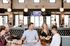 Vibrant restaurant scene with a group of friends enjoying food and drinks, highlighted by chic modern decor and warm lighting.
