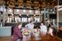 Chic dining space with rustic wood accents, featuring a lively group enjoying gourmet meals under stylish pendant lights.