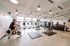Modern fitness center with natural lighting, featuring treadmills, spinning bikes, and a variety of weightlifting equipment.