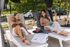 Relax in style with a modern poolside retreat featuring two women enjoying sun loungers, a refreshing summer drink, and a serene outdoor setting.
