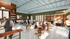 Vibrant caf&eacute;-style leasing office featuring modern decor, lively social interactions, and an inviting atmosphere.