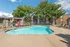 Community pool with sun chairs in front of apartments